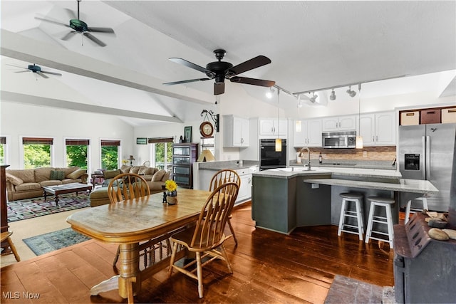 dining area featuring dark hardwood / wood-style flooring, sink, lofted ceiling with beams, and ceiling fan