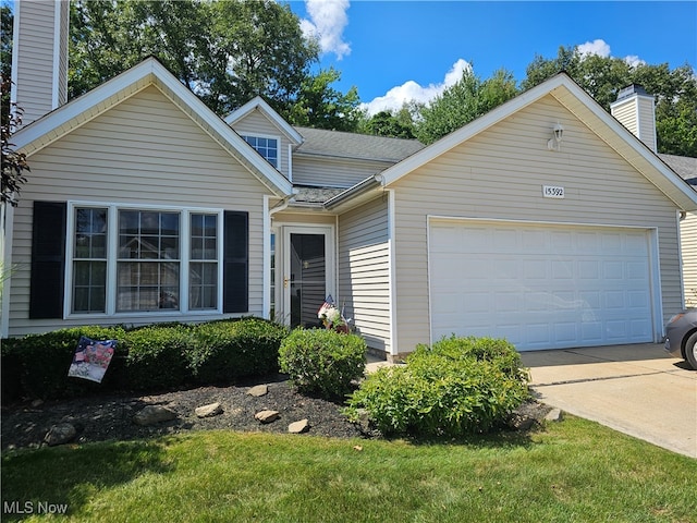 view of front of property featuring a garage and a front lawn