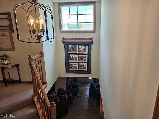 stairway featuring carpet flooring and a notable chandelier