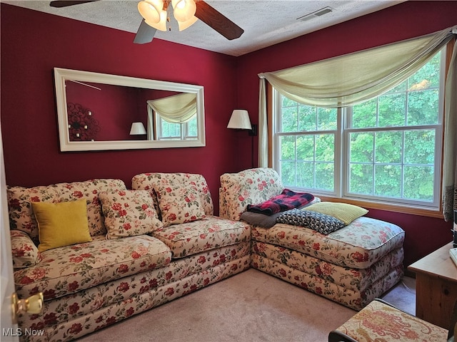 living room with carpet, a textured ceiling, and ceiling fan