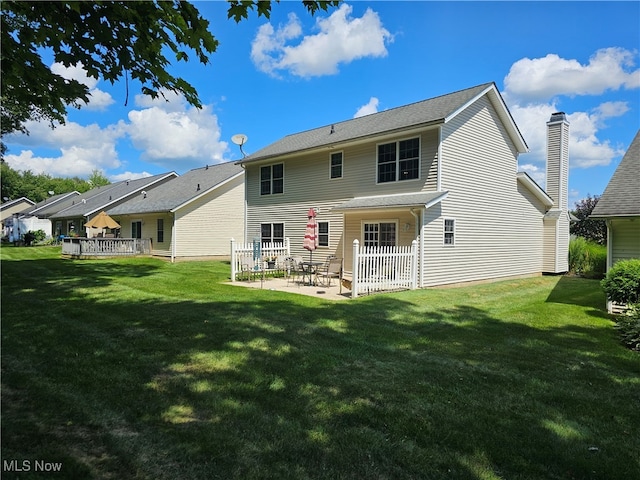 rear view of property featuring a patio area and a yard