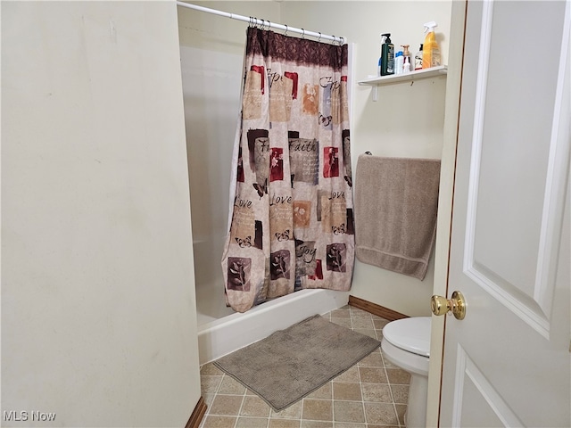 bathroom featuring toilet, a shower with curtain, and tile patterned floors