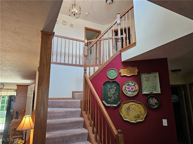 stairway featuring a notable chandelier