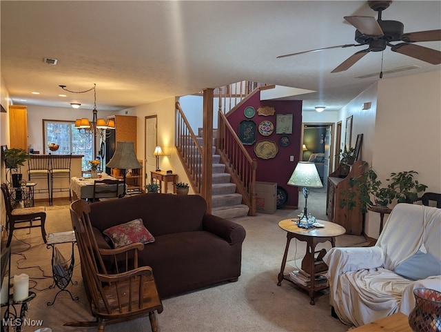 carpeted living room with ceiling fan with notable chandelier