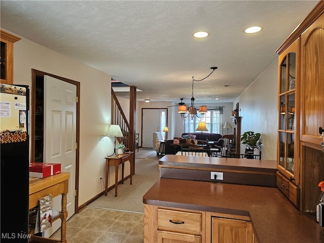 kitchen featuring a notable chandelier, black fridge, a textured ceiling, and decorative light fixtures