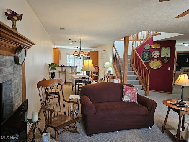 carpeted living room with a fireplace, a textured ceiling, and an inviting chandelier