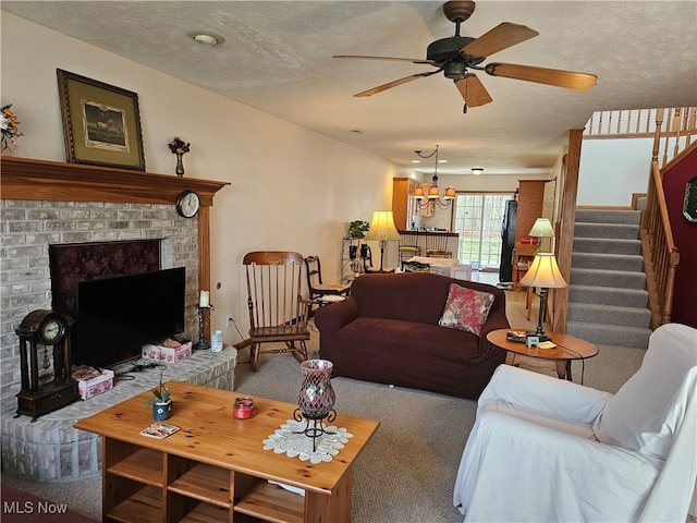 carpeted living room featuring ceiling fan, a fireplace, and a textured ceiling