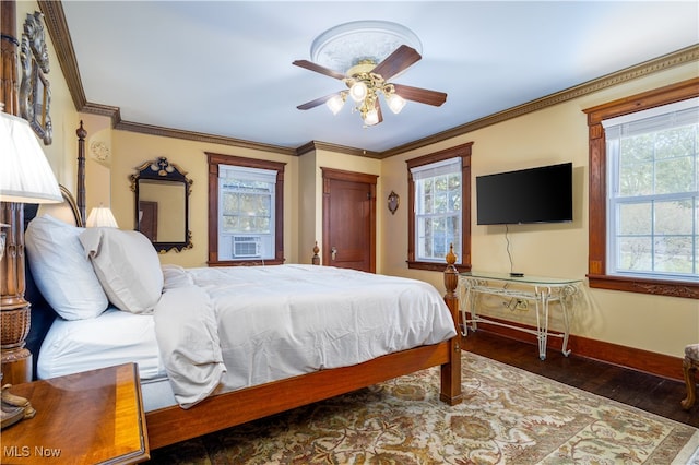 bedroom with dark hardwood / wood-style floors, crown molding, ceiling fan, and multiple windows