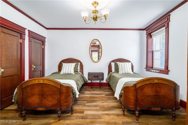 bedroom featuring a notable chandelier, ornamental molding, and hardwood / wood-style floors