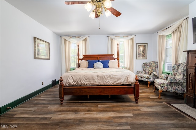 bedroom featuring ceiling fan, multiple windows, and hardwood / wood-style floors