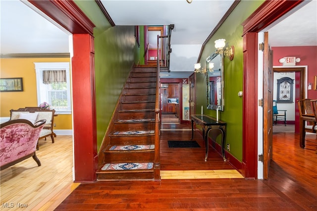 staircase featuring crown molding and hardwood / wood-style flooring