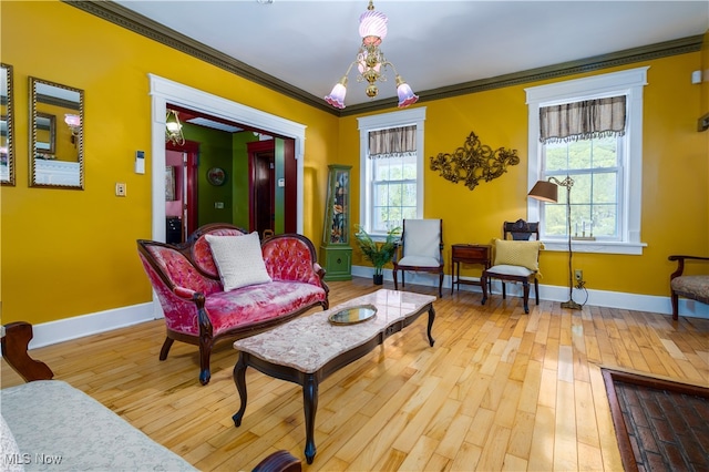 living room featuring a notable chandelier, crown molding, and light hardwood / wood-style floors