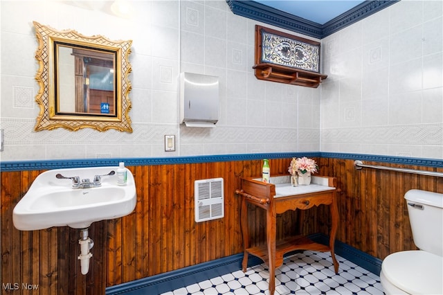 bathroom featuring tile patterned floors, tile walls, toilet, and sink