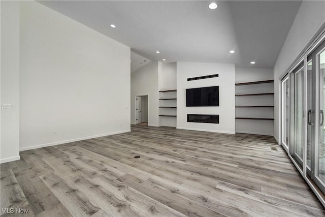 unfurnished living room featuring light hardwood / wood-style flooring and high vaulted ceiling