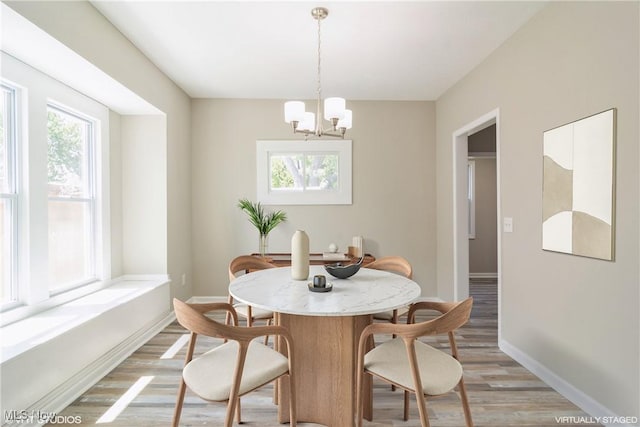 dining area with baseboards, plenty of natural light, and light wood finished floors