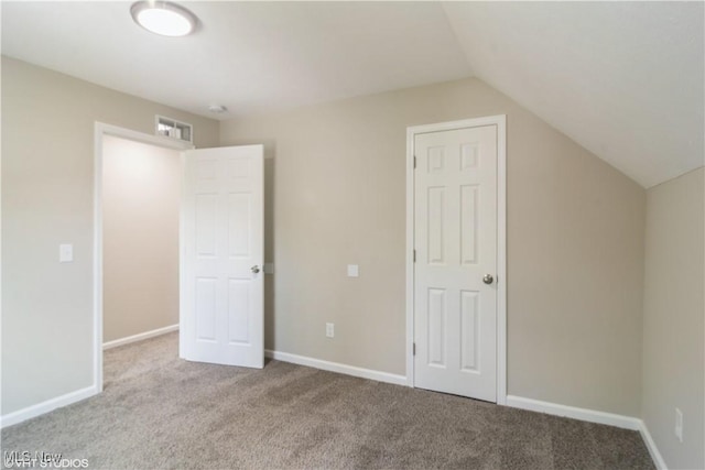 unfurnished bedroom featuring lofted ceiling, light colored carpet, and baseboards