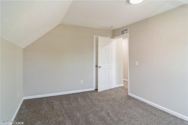 interior space with lofted ceiling, baseboards, visible vents, and carpet flooring