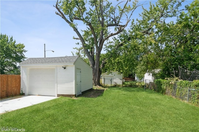 view of yard featuring a garage, an outbuilding, fence, and driveway