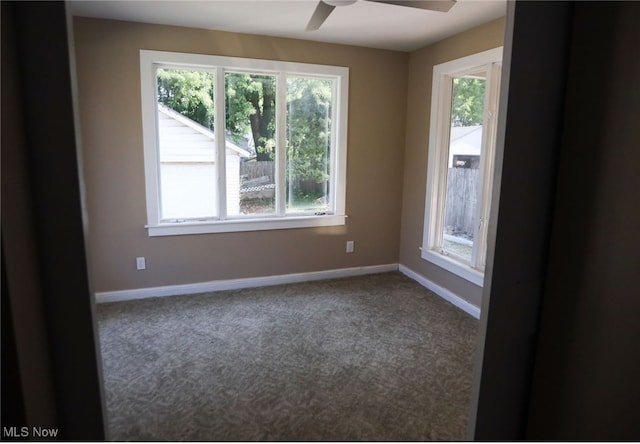 carpeted empty room with ceiling fan and a wealth of natural light