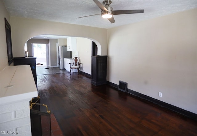 unfurnished living room featuring ceiling fan, a textured ceiling, and wood-type flooring