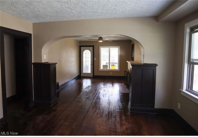 entrance foyer with ceiling fan, dark wood-type flooring, and a textured ceiling