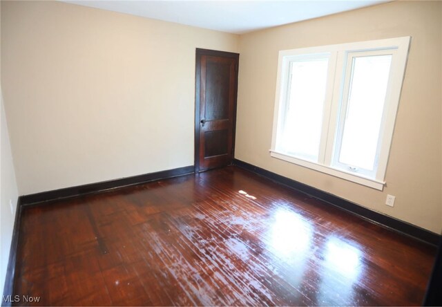 empty room featuring a healthy amount of sunlight and hardwood / wood-style floors