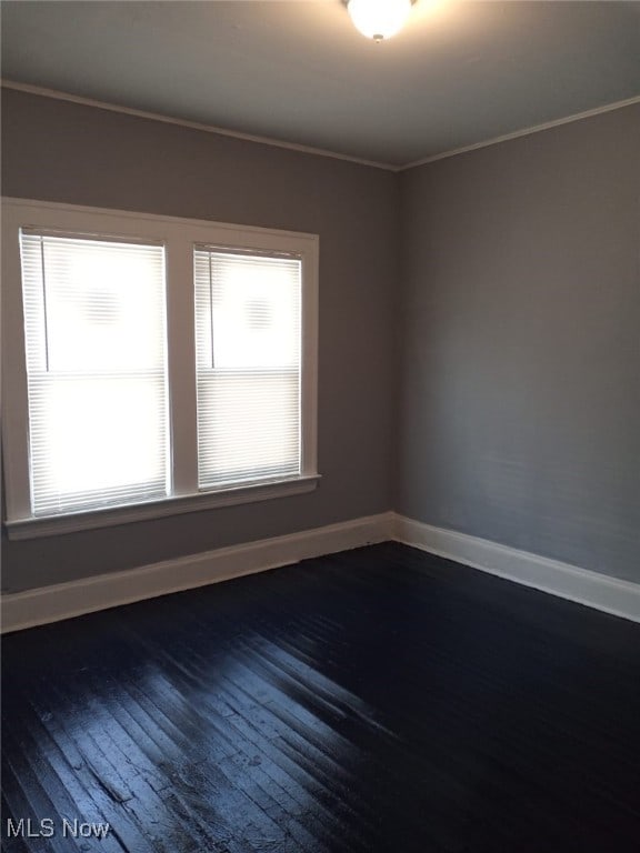 unfurnished room featuring wood-type flooring and ornamental molding