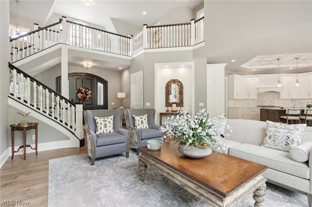 living room featuring a raised ceiling, hardwood / wood-style floors, and a high ceiling