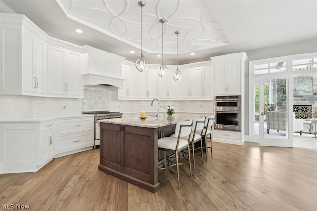 kitchen featuring light wood-type flooring, white cabinets, and stainless steel appliances