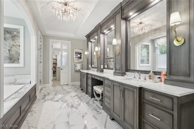 bathroom featuring a bathing tub, a tray ceiling, tile patterned flooring, an inviting chandelier, and vanity