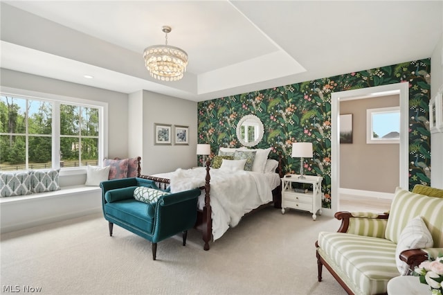 carpeted bedroom with a notable chandelier and a raised ceiling