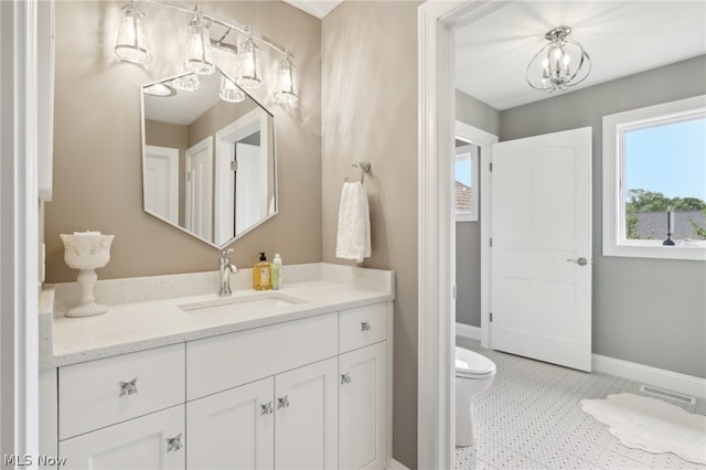 bathroom featuring vanity, toilet, an inviting chandelier, and tile patterned flooring