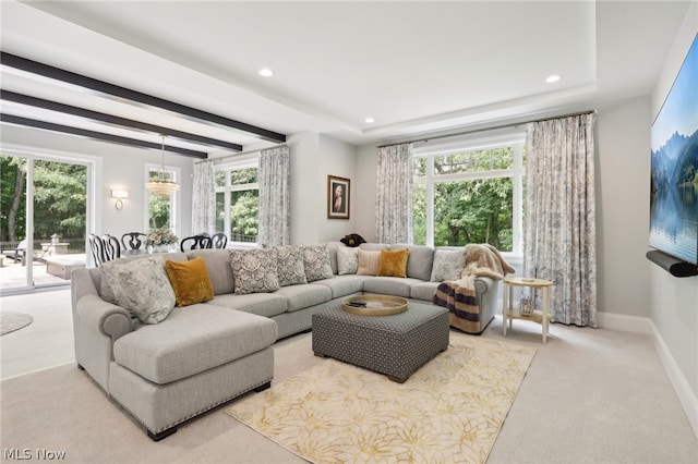 living room with light colored carpet, plenty of natural light, and a tray ceiling