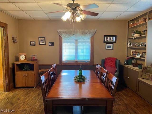 dining room featuring hardwood / wood-style flooring, a drop ceiling, and ceiling fan