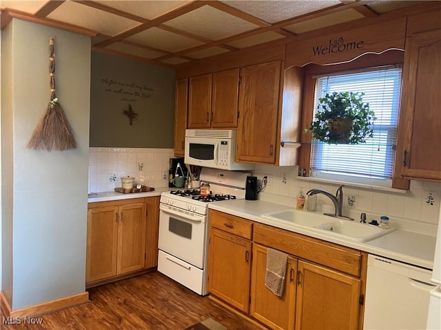 kitchen featuring backsplash, sink, dark hardwood / wood-style floors, and white appliances