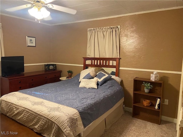 carpeted bedroom featuring ceiling fan and ornamental molding