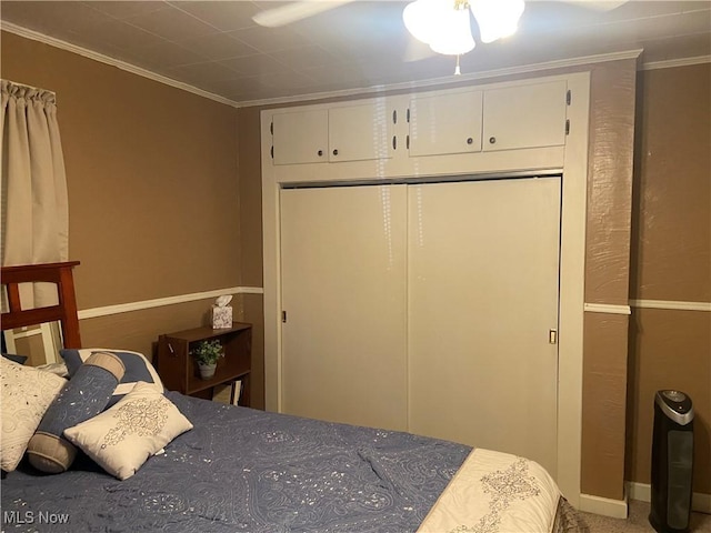 bedroom with carpet flooring, a closet, ceiling fan, and crown molding