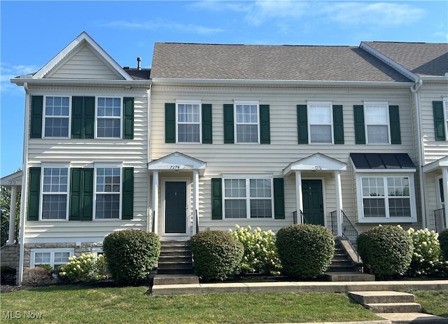 townhome / multi-family property featuring a front lawn