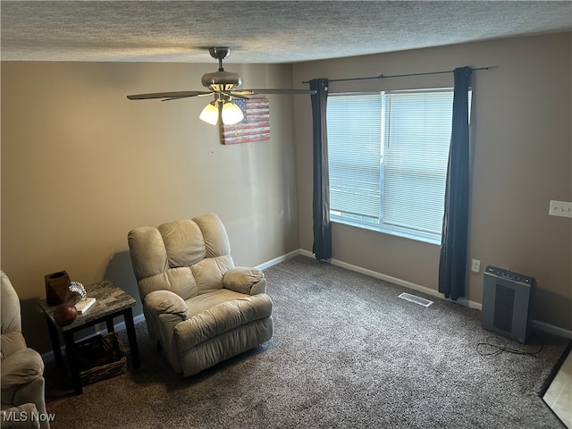 sitting room with ceiling fan, a textured ceiling, plenty of natural light, and carpet