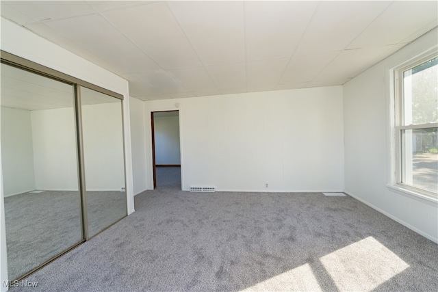 unfurnished bedroom featuring light carpet and a closet