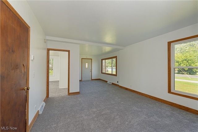 carpeted spare room featuring plenty of natural light