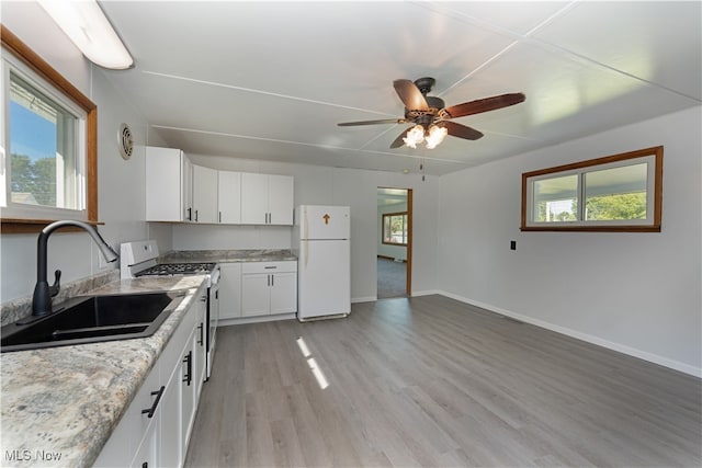 kitchen featuring range, fridge, light hardwood / wood-style floors, sink, and white cabinets