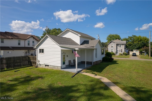 back of house featuring a patio area and a lawn