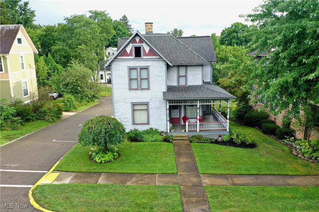 victorian-style house featuring a front yard and a porch