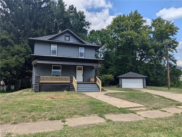 view of front of home featuring an outbuilding, covered porch, a front lawn, and a garage