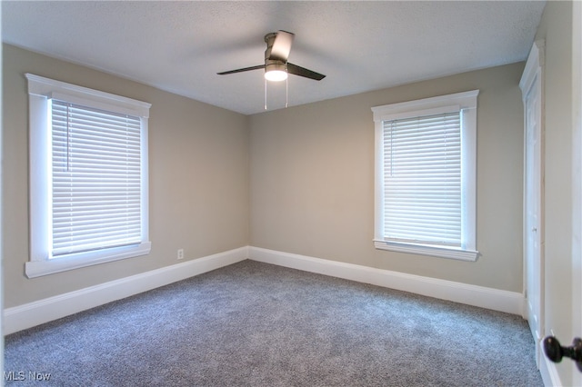 carpeted spare room featuring ceiling fan, a healthy amount of sunlight, and a textured ceiling