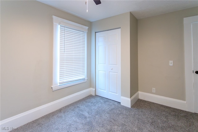 unfurnished bedroom with carpet flooring, a closet, and ceiling fan