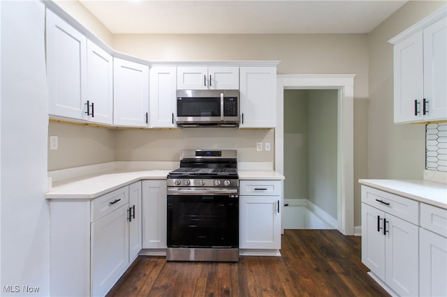 kitchen with dark wood-type flooring, stainless steel appliances, and white cabinets