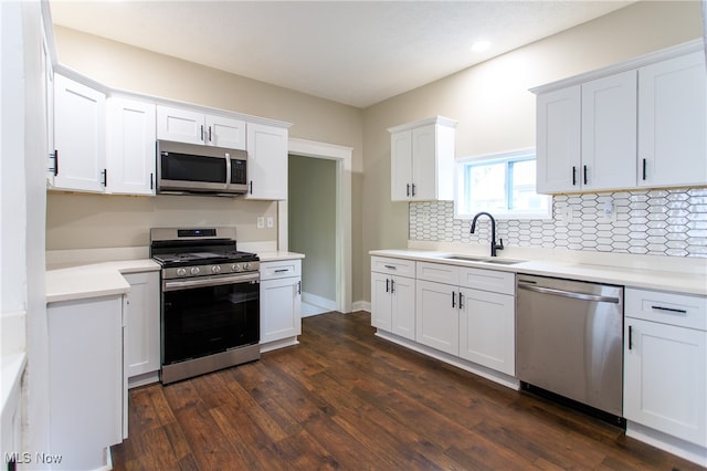 kitchen with decorative backsplash, dark wood-type flooring, sink, white cabinetry, and appliances with stainless steel finishes