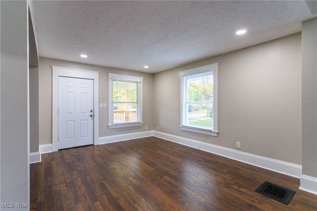 entrance foyer with a textured ceiling and dark hardwood / wood-style flooring